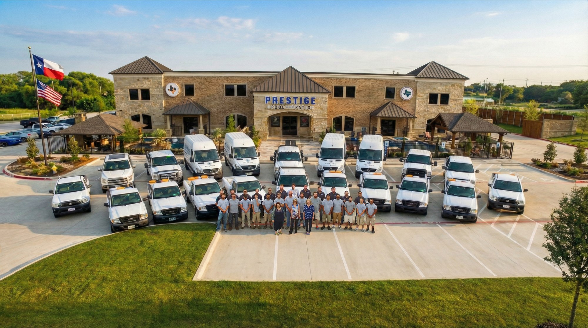 The full Prestige Pool & Patio team with company vehicles in front of the Frisco showroom